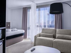 أجنحة نوفوتيل باريس إيسي ليه مولينو في إيسي ليه مولينو: غرفة معيشة مع أريكة وسرير +109 صور