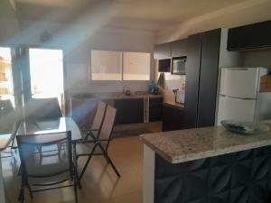 ボイトゥヴァにあるmorada do descansoのテーブルと椅子と冷蔵庫のあるキッチン