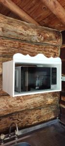 a microwave hanging on a wall in a cabin at Mangoré Rústico Cabaña 1 in La Granja