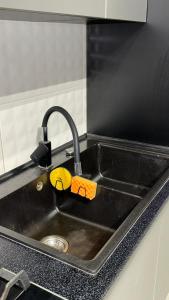 a black kitchen sink with a faucet and a sink at Люкс студия в центре города in Zarechʼye +33 photos