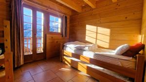 a bedroom with two beds in a wooden cabin at Chalet La Giete 6 personnes La Forclaz in Haudères