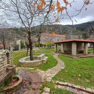 a park with a tree and a building at Vrachni Stone House in Kalavrita