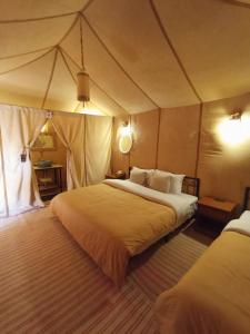 a bedroom with two beds in a tent at Khamlia Desert Camp in Merzouga +41 photos