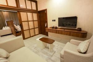 a living room with a television and a couch at Town Square Residency in Kommeri +27 photos