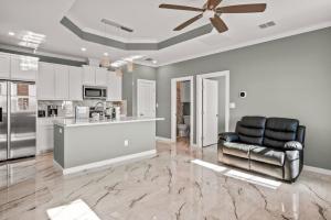 Casa San Juan Jr. في ميناء أرانساس: غرفة معيشة مع مروحة سقف ومطبخ