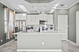 Casa San Juan Jr. في ميناء أرانساس: مطبخ بدولاب بيضاء وقمة بيضاء