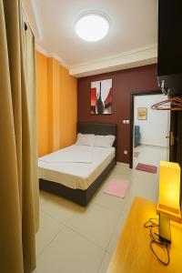 a bedroom with a bed with orange and brown walls at Loïc Appart in Douala