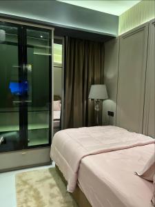 a bedroom with a bed and a large window at Delft Apartemen in Gusung