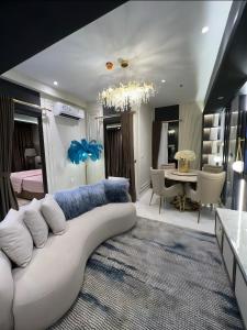 a living room with a white couch and a dining room at Delft Apartemen in Gusung