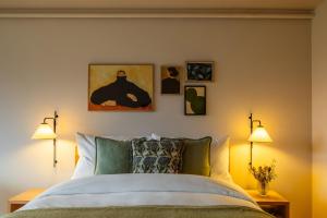 a bedroom with a bed with four pictures on the wall at La Senda Smart Hotel Zuoz in Zuoz +9 photos