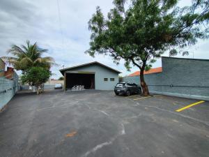 a parking lot with a car parked in front of a garage at Hotel Pousada Narandiba in Narandiba