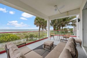 een woonkamer met een bank en uitzicht op de oceaan bij Oceanfront 6BR Indoor Pool Theater Funky Fun in Cocoa Beach