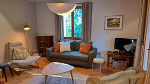 a living room with a couch and chairs and a tv at Maison Aksel in Beaumes-de-Venise