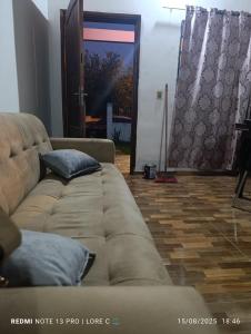 a living room with a brown couch and a wooden floor at Casa MARAIMAU in Encarnación +1 photo