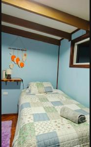 a bedroom with a bed with a quilt on it at Cabaña privada con acceso a playa in Quilquico