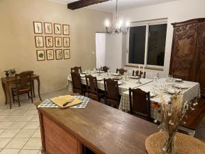 a dining room with a long table with white tablecloths at gîte La Maison d'Odette in Saint-Rémy-du-Plein +9 photos