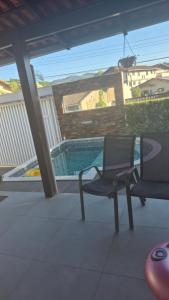 a patio with a chair and a swimming pool at Casa com piscina, suite com hidro em Blumenau in Blumenau +14 photos