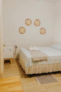 a bedroom with two beds and three baskets on the wall at Hospedaria Oliveira - Santo Amaro do Maranhão in Queimada +16 photos