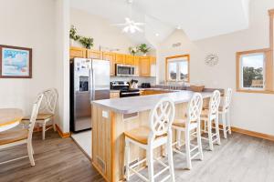a kitchen with a table and chairs and a refrigerator at 1600 - 5 O`clock Somewhere in Corolla