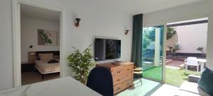 ein Wohnzimmer mit einem Fernseher auf einer Kommode und ein Wohnzimmer mit in der Unterkunft Take it easy in Corralejo in Corralejo