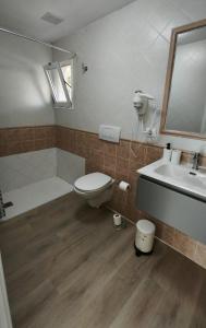 ein Badezimmer mit Toilette, Waschbecken und Spiegel in der Unterkunft Take it easy in Corralejo in Corralejo + 11 Fotos