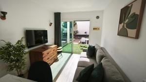 ein Wohnzimmer mit Sofa und Flachbildfernseher in der Unterkunft Take it easy in Corralejo in Corralejo