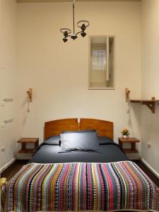 a bedroom with a large bed with a colorful blanket at Hostal Ekeka House in Valparaíso