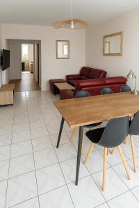 a living room with a table and a couch at Spacieux T4 lumineux avec balcon confort, calme et modernité à Joué-lès-Tours in Joue-les-Tours