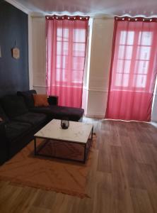 a living room with a couch and a coffee table at Le Petit Logis Noblat 2 in Saint-Léonard-de-Noblat
