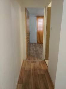 an empty hallway of an apartment with wood floors at Le Petit Logis Noblat 2 in Saint-Léonard-de-Noblat