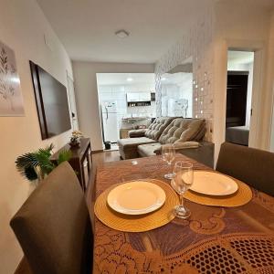a dining room with a table and a living room at Grace Prime Loft - aconchego em Extrema MG in Extrema
