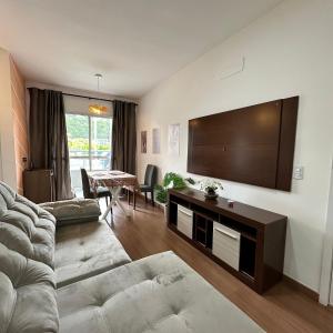 a living room with a couch and a flat screen tv at Grace Prime Loft - aconchego em Extrema MG in Extrema +89 photos