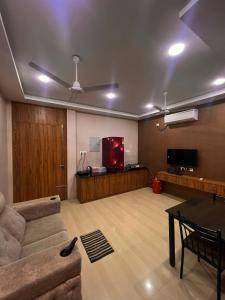 Alma by MyCasa Elegant 2BHK Stay in TTK Road في تشيناي: غرفة معيشة مع أريكة وتلفزيون بشاشة مسطحة