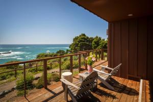 a balcony with two chairs and a table with a view of the ocean at Heritage House Resort & Spa in Little River