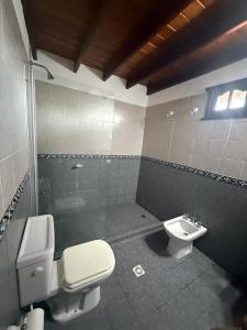 a bathroom with a toilet and a sink at Cabañas Costa Alta in Mina Clavero
