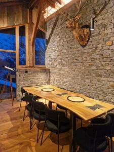 a wooden table and chairs in a room with a brick wall at Chalet du cerf fragment in Saint-Martin-de-Belleville