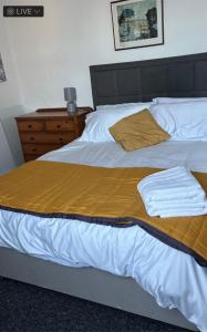 a bed with white sheets and a yellow blanket at 28 Russell road in Bristol