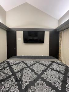 Schlafzimmer mit einem Bett und einem TV an der Wand in der Unterkunft Hotel-Style Private Suite-Lake View-Gardens in Lake Wales