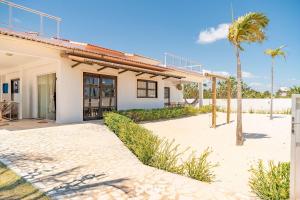 a house with a palm tree in front of it at Casa Palm Paradise em Touros by Qavi in Touros