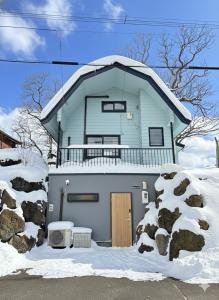 a blue house with snow on the ground at Toya Tiny Cabin 洞爺タイニーキャビン in Lake Toya