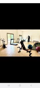 appartement résidence garden paradise plage bouznika في بوزنيقة: صالة ألعاب رياضية بها العديد من أجهزة المشي والدراجات الرياضية