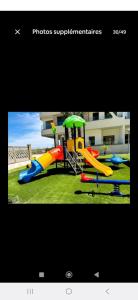 appartement résidence garden paradise plage bouznika في بوزنيقة: صورة ملعب مع زحليقة