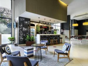 a lobby with chairs and a table and a bar at ibis BH Afonso Pena Savassi in Belo Horizonte