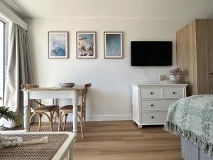a bedroom with a table and a tv on a wall at Beachfront Studio Fabulous Location in Deewhy
