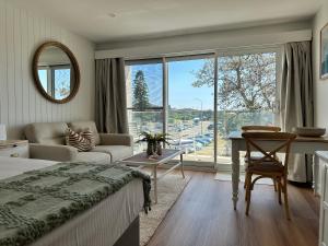 a bedroom with a bed and a table and a window at Beachfront Studio Fabulous Location in Deewhy