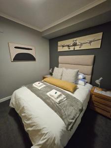 a bedroom with a large bed with two towels on it at At Leisure Apartment 2 in Stellenbosch