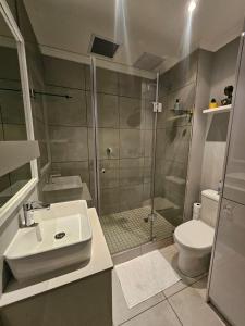 a bathroom with a shower and a sink and a toilet at At Leisure Apartment 2 in Stellenbosch +37 photos