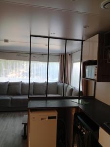 ein Wohnzimmer mit einem Sofa und einem großen Spiegel in der Unterkunft Spacieux mobil home 40 m2 tt conf 5 p in Fréjus