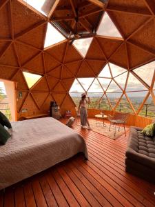 a woman walking in a large room with a bed at Prana Hills in Estación El Salto