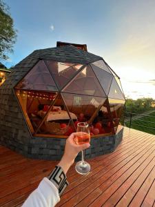 a person holding a glass of wine on a deck at Prana Hills in Estación El Salto